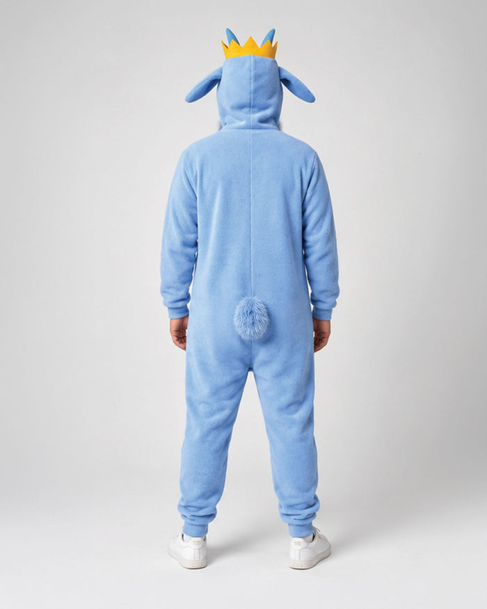 A person viewed from the back wearing a light blue animal-style hooded onesie with long ears, a small yellow and blue crown on the hood, and a fluffy blue tail at the back, standing against a light gray studio background.