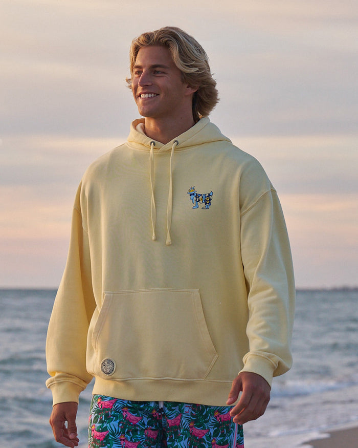 Man in yellow hoodie at the beach at sundown