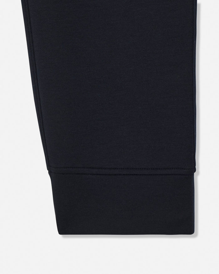 Close-up of a dark navy fabric cuff with a ribbed hem, shown against a plain white background.#color_black