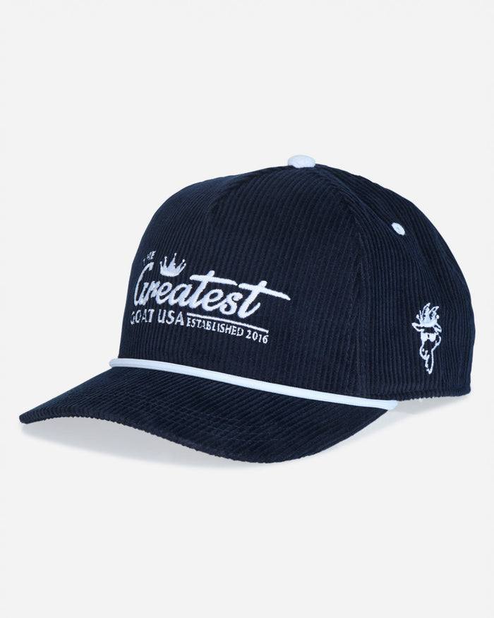A dark navy blue corduroy baseball cap with white embroidered text reading 'The Greatest 2016 USA ESTABLISHED 2016' on the front and a small white graphic on the side, shown on a light gray background.