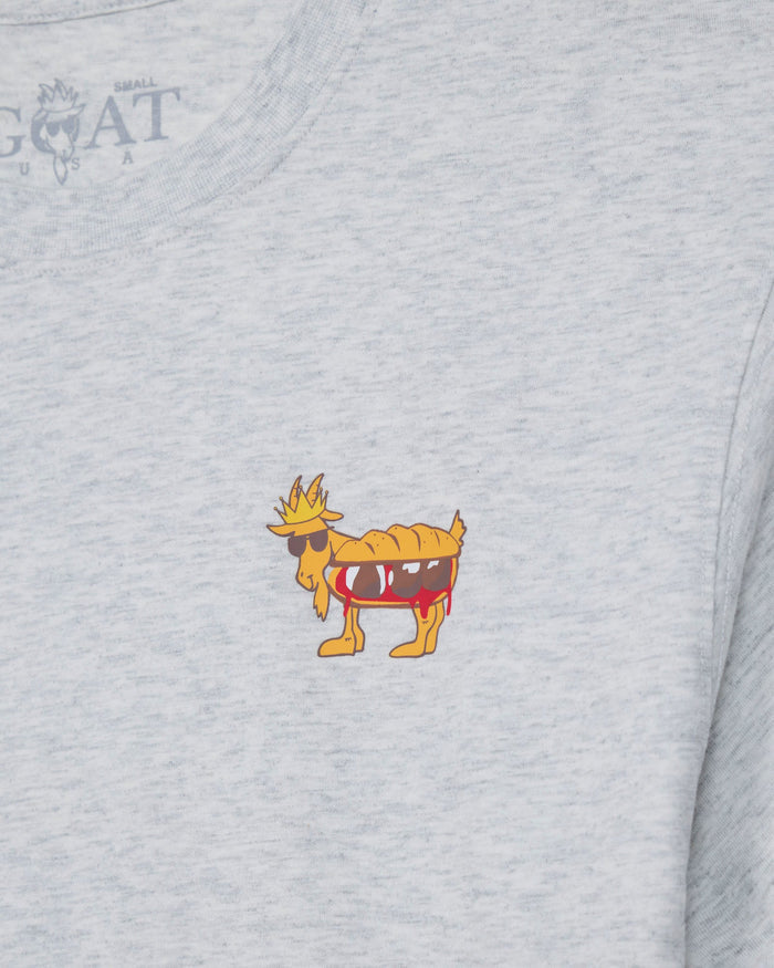 Close-up of a light heather gray t-shirt featuring a small cartoon graphic of a goat wearing sunglasses, with a faint 'GOAT USA' brand logo printed inside the collar.