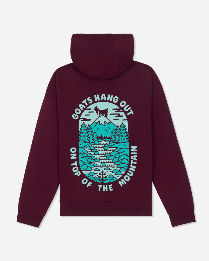 A maroon pullover hoodie shown from the back, featuring a large graphic print of a mountain scene in teal and white with the text 'GOATS HANG OUT ON TOP OF THE MOUNTAIN'.