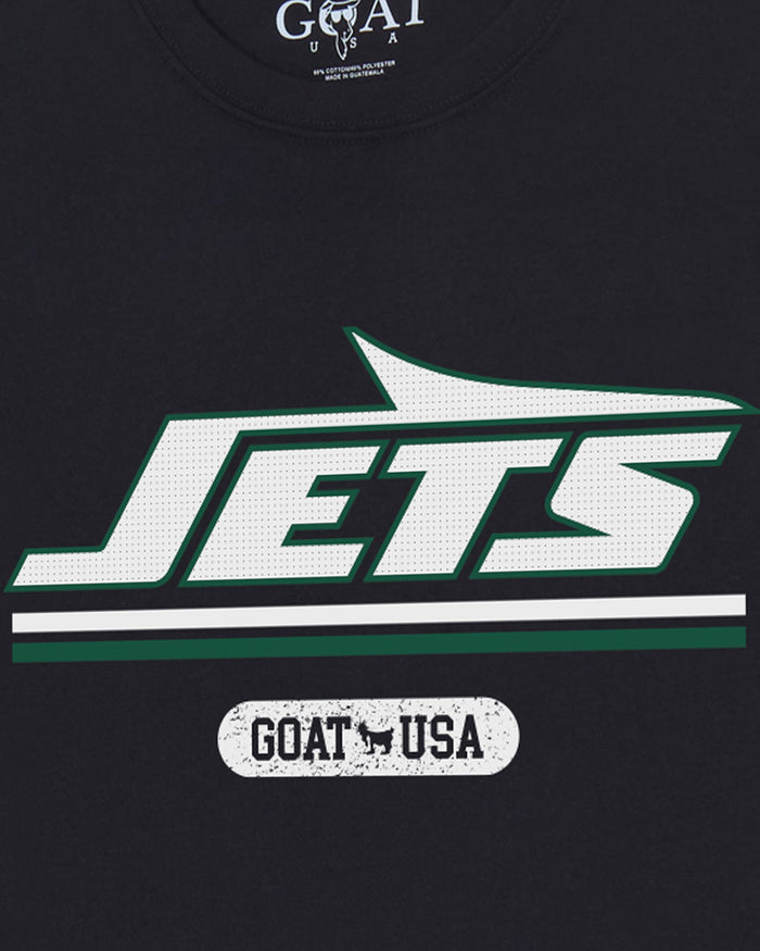 Close-up of a black t-shirt featuring a large white and green 'JETS' graphic with a white stripe and a distressed 'GOAT USA' label below it.