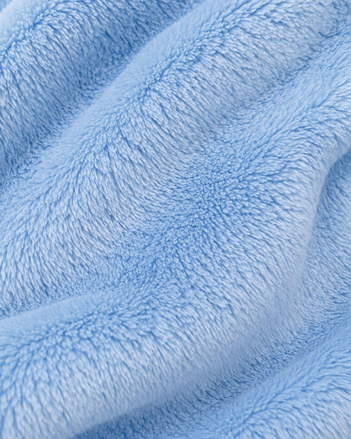 A close-up of light blue plush faux fur fabric with soft, textured folds.