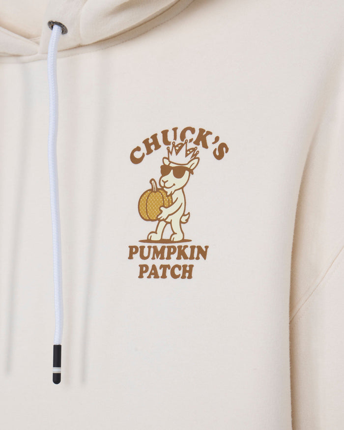 Close-up of a cream-colored hoodie featuring a brown graphic print of a cartoon goat wearing sunglasses and holding a pumpkin, with the text 'CHUCK'S PUMPKIN PATCH'.