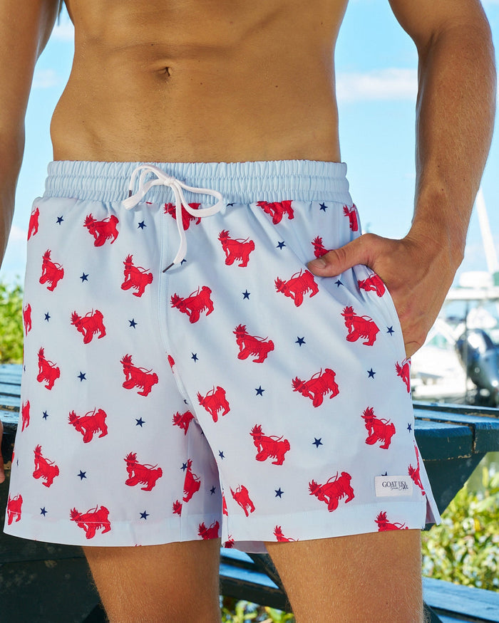 Man with one hand in pocket wearing a bathing suit with a lobster goat pattern