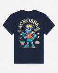 A navy blue short-sleeve t-shirt shown from the back, featuring a large graphic of a blue lacrosse player wearing a gold crown and holding a lacrosse stick, with the word 'LACROSSE' printed above in cream.