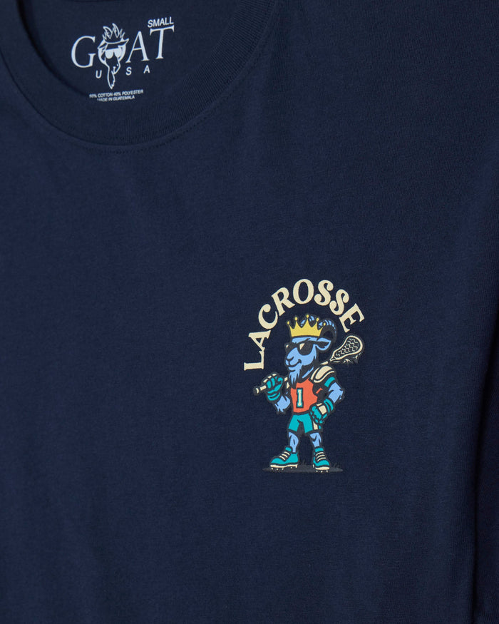 Close-up of a navy blue t-shirt featuring a colorful graphic of a lacrosse player with the word 'LACROSSE' arched above, and a white 'GOAT USA' neck label.