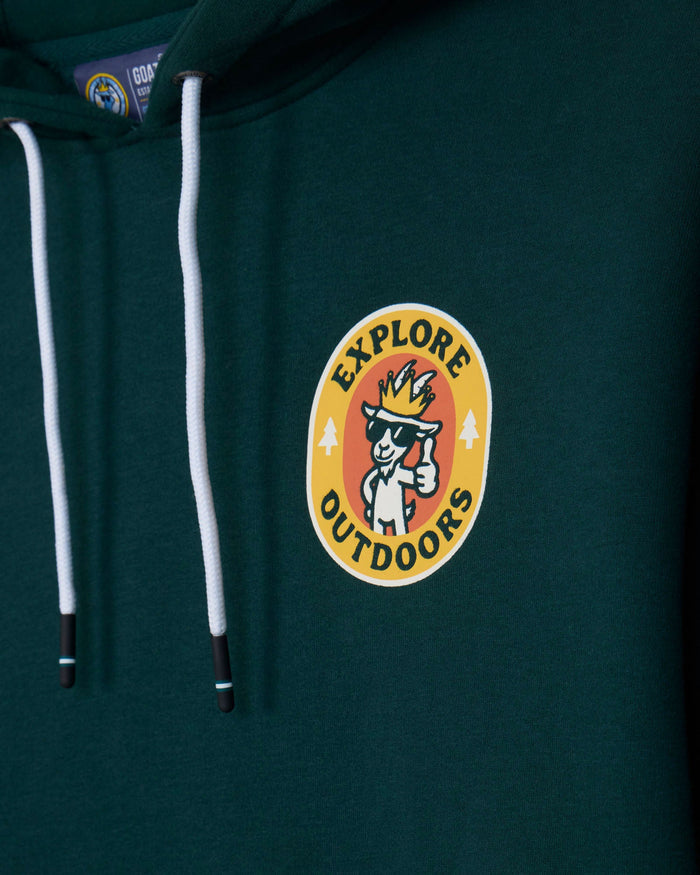 Close-up of a dark green hoodie with white drawstrings and a circular chest graphic that reads 'EXPLORE OUTDOORS' around a cartoon explorer character.