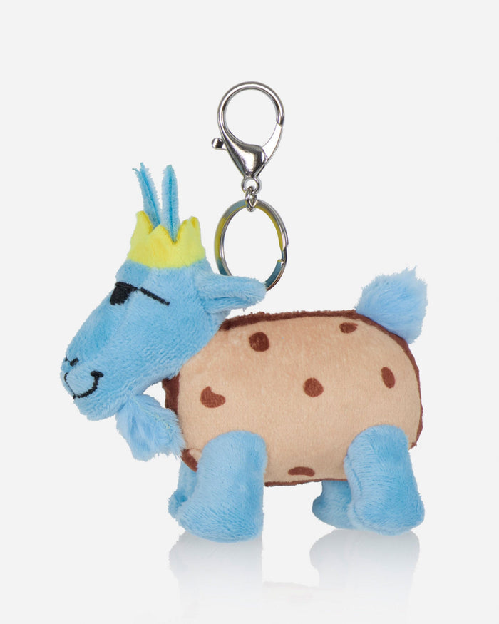 A plush goat bag charm styled like a cookie, featuring a light blue body, a beige body with brown spots, a yellow crown, and a silver metal clasp on a light gray background.