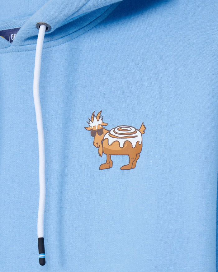 Close-up of a light blue hoodie featuring a white drawstring and a small cartoon graphic of a brown goat wearing sunglasses and a white swirl top, printed on the chest.