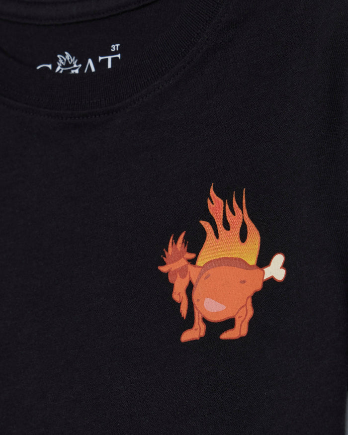 Close-up of a black t-shirt featuring a cartoon graphic of a flaming goat on the chest, with a white stylized brand logo printed inside the collar.