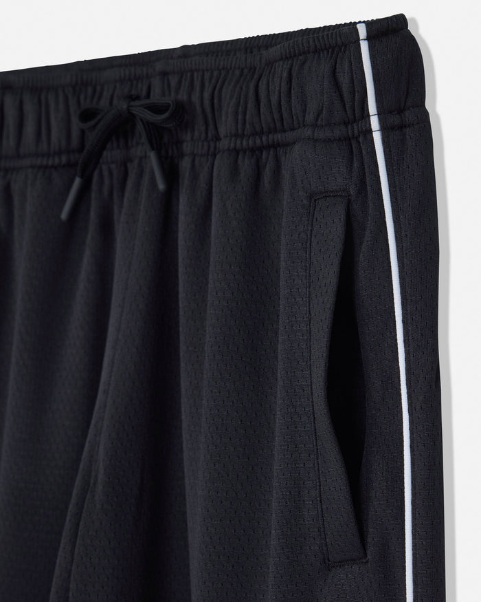 Close-up of black athletic shorts with a textured mesh fabric, featuring an elastic drawstring waistband and a white side stripe.#color_black