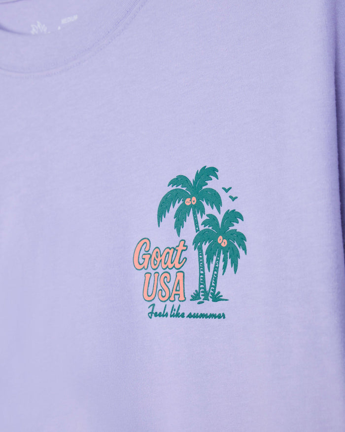 Periwinkle crop tee with palm tree design and 'Goat USA' text on a plain background